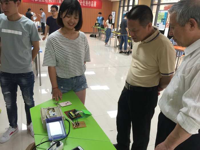 毕业生为黄阿火书记讲解作品.jpg