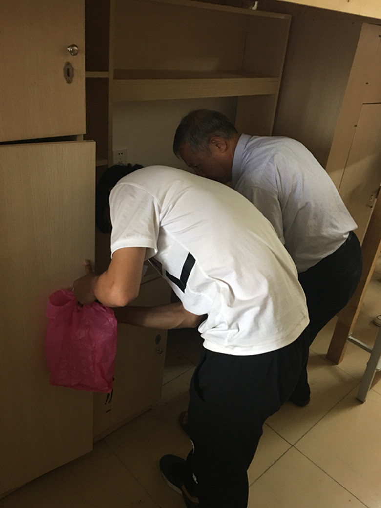 系主任郑老师和辅导员亲自在检查柜子.jpg